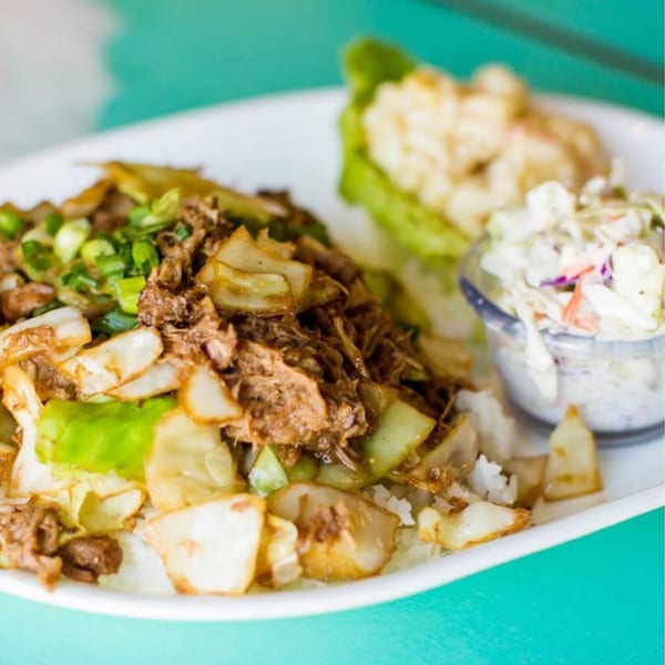 Hula Pizzeria & Grill's plate lunch with shredded meat, cabbage, rice, coleslaw, and macaroni salad.